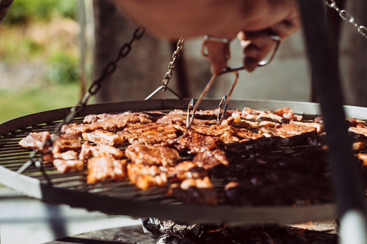 Grilled steaks and skewers on an outdoor grill, illustrating the wood-fired flavor profile that anchors Father’s Day catering menus on the Space Coast.