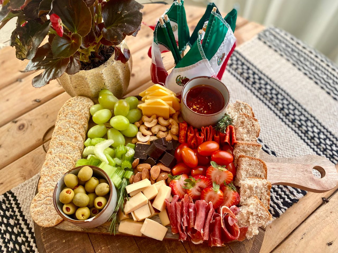 Charcuterie grazing board with cheeses, fruit, and snacks for a gathering