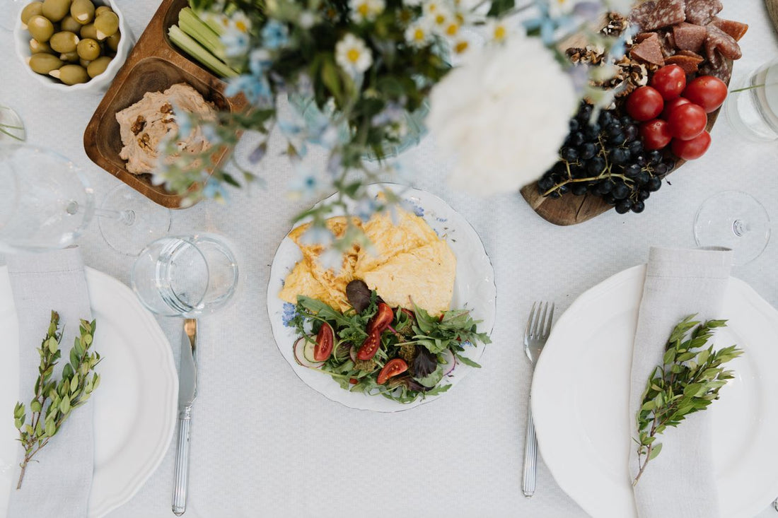 Outdoor catering table with fresh, colorful summer dishes arranged for an event in the sun
